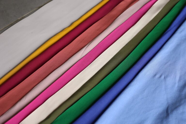 Vibrant fabrics arranged in a rainbow pattern showcasing a spectrum of colors.